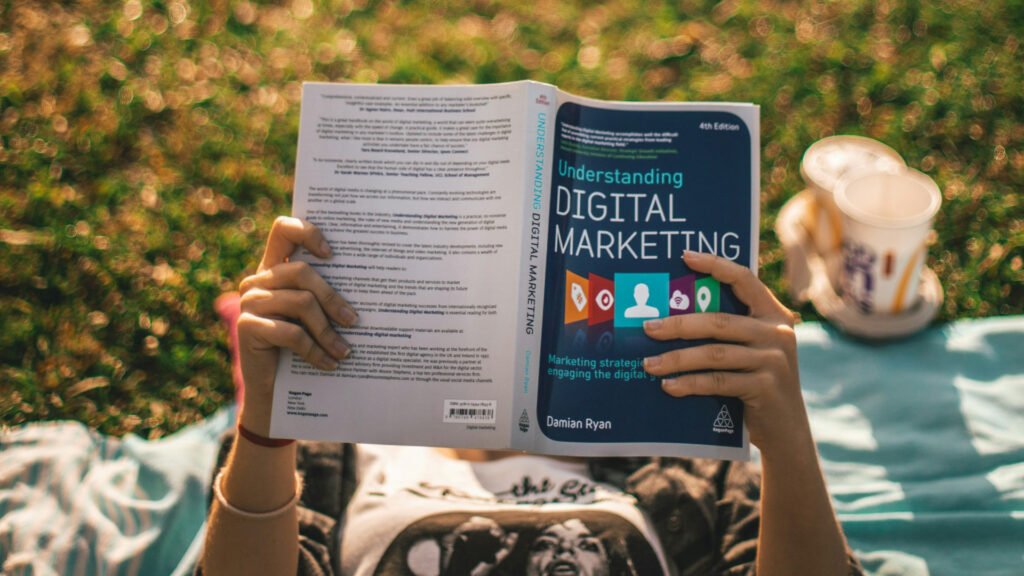 person laying on the grass reading a digital marketing book learning how to Maximize Your ROI